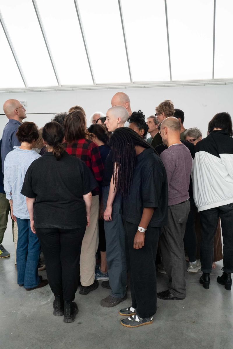 A group of people huddling close together during a choreography workshop