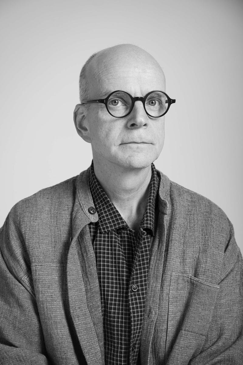 A portait of a man, with glasses, looking into the camera