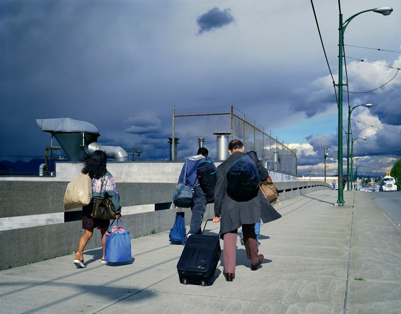 Jeff Wall, Overpass. Three people cross a flyover or bridge.